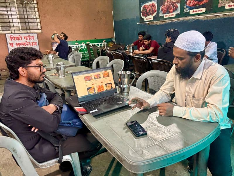 A Nukaazo team member working with a shop owner at a neighbourhood eatery